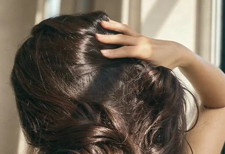 Fingers running through thick, healthy hair